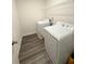 Functional laundry room featuring modern appliances, storage shelf, and durable flooring at 330 Cotton Tail Ln, Villa Rica, GA 30180