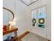 Bright foyer featuring a console table, decorative mirror, and glass-paneled doors leading to the outside at 4960 Shade Creek Xing, Cumming, GA 30028