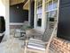 Close-up of the front porch with comfortable rocking chairs and stone flooring at 4960 Shade Creek Xing, Cumming, GA 30028