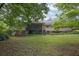 Expansive backyard with lush green lawn, mature trees, and rear view of home at 5309 Ashley Se Dr, Conyers, GA 30094