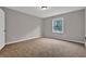 This bedroom features neutral paint and carpet, with a single window for natural light at 5309 Ashley Se Dr, Conyers, GA 30094