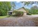 Home exterior with side-entry garage, brick accents, and a long driveway surrounded by lush greenery at 5309 Ashley Se Dr, Conyers, GA 30094