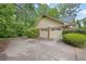 Attached two-car garage with brick facade and adjacent driveway framed by green landscaping at 5309 Ashley Se Dr, Conyers, GA 30094