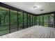 Screened-in porch with wood flooring offers a view of the serene, wooded backyard at 5309 Ashley Se Dr, Conyers, GA 30094