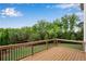Elevated wood deck with railing overlooking the backyard and lush trees at 6265 Bellmoore Park Ln, Johns Creek, GA 30097