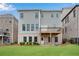 Back of a two-story house with a deck and patio overlooking a well-maintained backyard at 6265 Bellmoore Park Ln, Johns Creek, GA 30097