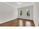Bright bedroom with hardwood floors and natural light from two windows creating a serene space at 6265 Bellmoore Park Ln, Johns Creek, GA 30097