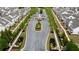 Aerial view down a tree lined street of the community entrance with manicured landscaping at 6265 Bellmoore Park Ln, Johns Creek, GA 30097
