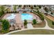 Aerial view of a community pool with lounge chairs, splash pad, playground, and clubhouse at 6265 Bellmoore Park Ln, Johns Creek, GA 30097