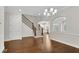 Elegant entryway with hardwood floors, staircase with iron spindles, and modern chandelier at 6265 Bellmoore Park Ln, Johns Creek, GA 30097