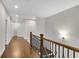 Upstairs hallway with wood floors, iron railing, and natural light at 6265 Bellmoore Park Ln, Johns Creek, GA 30097