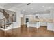 Well-lit kitchen with a large central island, white cabinets, stainless steel appliances, and view to the stairs at 6265 Bellmoore Park Ln, Johns Creek, GA 30097