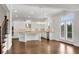 Open-concept kitchen with a central island, white cabinets, stainless steel appliances, and hardwood floors at 6265 Bellmoore Park Ln, Johns Creek, GA 30097