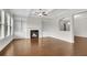 Spacious living room with hardwood floors, a fireplace, built-in bookshelves, and a view to the dining area at 6265 Bellmoore Park Ln, Johns Creek, GA 30097