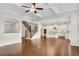 Open concept living room with hardwood floors, stairs, and view to the kitchen with a central island at 6265 Bellmoore Park Ln, Johns Creek, GA 30097