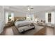 Staged main bedroom with a ceiling fan, tray ceilings, bedside tables and a sitting area at 6265 Bellmoore Park Ln, Johns Creek, GA 30097