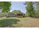 Large, well-maintained backyard showing the home, covered patio, and mature trees at 6470 Windsor Dr, Acworth, GA 30102