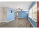 Open-concept living room with blue walls, luxury vinyl plank flooring, and many windows at 1825 Sw Willis Mill Rd, Atlanta, GA 30311