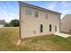 Two-story home featuring a neutral siding, windows, and a door leading to a small concrete patio and grassy backyard at 4452 Belcamp Rd, Fairburn, GA 30213