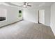 Light-filled main bedroom featuring soft carpet, a ceiling fan, and large windows overlooking the backyard at 4452 Belcamp Rd, Fairburn, GA 30213
