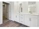 Bright bathroom featuring double sinks with white cabinets, modern fixtures, and wood-look flooring at 173 Soseby Lake Ln, Grayson, GA 30017