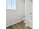 Bathroom with tile surround and wood-look vinyl floors at 173 Soseby Lake Ln, Grayson, GA 30017