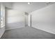 Neutral bedroom featuring gray carpet, bright white walls, and an open closet at 173 Soseby Lake Ln, Grayson, GA 30017