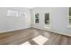 Sun-filled room with neutral walls, wood-look floors, and a door with multiple windows offering views of the outdoors at 173 Soseby Lake Ln, Grayson, GA 30017