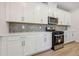 Well-equipped kitchen featuring white cabinets, stainless steel appliances, and stylish backsplash at 376 Tallulah Ln, Grayson, GA 30017