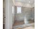 Elegant walk-in shower with gray tile, a glass enclosure, a built-in seat, and a window providing natural light at 371 Tallulah Ln, Grayson, GA 30017