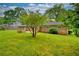 The home's backyard, featuring a large lawn and stone patio with fire pit, perfect for outdoor entertaining and relaxing at 4507 N Peachtree Rd, Dunwoody, GA 30338