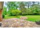 Backyard featuring a stone patio and a fire pit for outdoor entertaining at 4507 N Peachtree Rd, Dunwoody, GA 30338