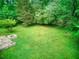 Large backyard featuring a stone patio and a fire pit, offering ample space for outdoor activities and enjoyment at 4507 N Peachtree Rd, Dunwoody, GA 30338