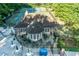 Elevated shot of a clubhouse and patio with multiple tables next to tennis courts and pool area with lush landscaping at 4507 N Peachtree Rd, Dunwoody, GA 30338