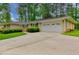 Single story home with a large driveway leading to a two car garage and well manicured front lawn at 4507 N Peachtree Rd, Dunwoody, GA 30338