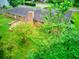 Back of house shows a brick facade, stone patio, and a fire pit surrounded by mature trees and lush greenery at 4507 N Peachtree Rd, Dunwoody, GA 30338