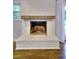 Bright fireplace has painted white brick surround with wooden mantle and hearth at 4507 N Peachtree Rd, Dunwoody, GA 30338