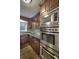 A modern kitchen with stainless steel appliances and dark wooden cabinets at 4507 N Peachtree Rd, Dunwoody, GA 30338