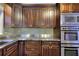 A modern kitchen with stainless steel countertops, dark wood cabinets, and appliances at 4507 N Peachtree Rd, Dunwoody, GA 30338