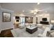 Staged living room with white sofas, fireplace and large windows bring the outside in at 4507 N Peachtree Rd, Dunwoody, GA 30338