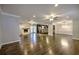 Expansive living room showcasing hardwood floors, white fireplace, and seamless flow to the kitchen at 4507 N Peachtree Rd, Dunwoody, GA 30338