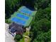 Aerial view of tennis courts next to clubhouse with outdoor seating surrounded by lush greenery at 4507 N Peachtree Rd, Dunwoody, GA 30338
