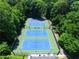 Aerial view of community tennis courts with blue playing surface and surrounding green landscaping at 4507 N Peachtree Rd, Dunwoody, GA 30338