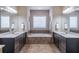 A luxurious bathroom featuring a soaking tub, dual sinks, and plenty of counter space at 486 Raven Brook Ln, Suwanee, GA 30024