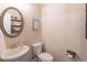 Powder room featuring a decorative mirror and dark wood accents next to a white toilet and sink at 486 Raven Brook Ln, Suwanee, GA 30024