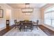 Elegant dining room featuring a modern light fixture, wainscoting and large area rug for gatherings at 486 Raven Brook Ln, Suwanee, GA 30024