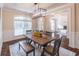 Bright dining room featuring a table, modern lighting fixture, wainscoting and large windows for a welcoming space at 486 Raven Brook Ln, Suwanee, GA 30024