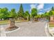 Community entrance with brick pillars, landscaping, and gated access at 486 Raven Brook Ln, Suwanee, GA 30024