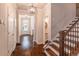 Beautiful hallway featuring hardwood floors, stairs, modern lighting fixtures and a glimpse of a half bathroom at 486 Raven Brook Ln, Suwanee, GA 30024