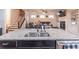 Kitchen island featuring granite counters and stainless steel dishwasher with view to the living room fireplace at 486 Raven Brook Ln, Suwanee, GA 30024